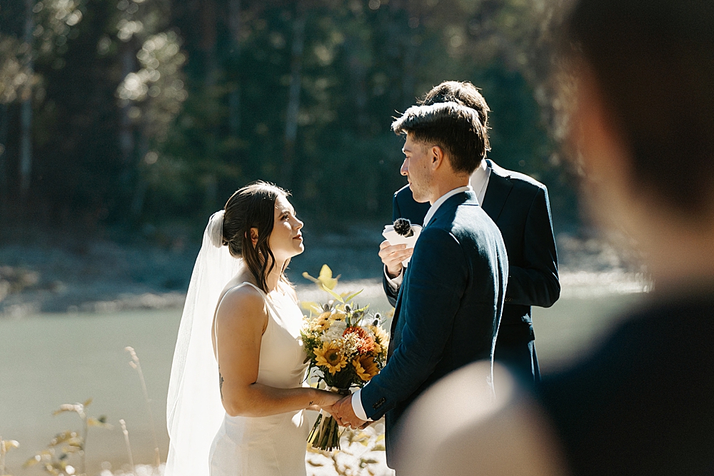 Bride and groom looking at each other during their Cowlitz River small wedding ceremony.
