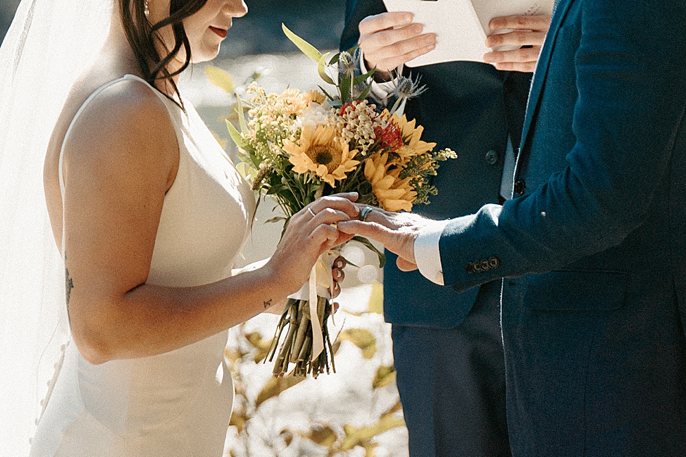Bride putting wedding band on groom's finger during their Packwood, WA small wedding ceremony.