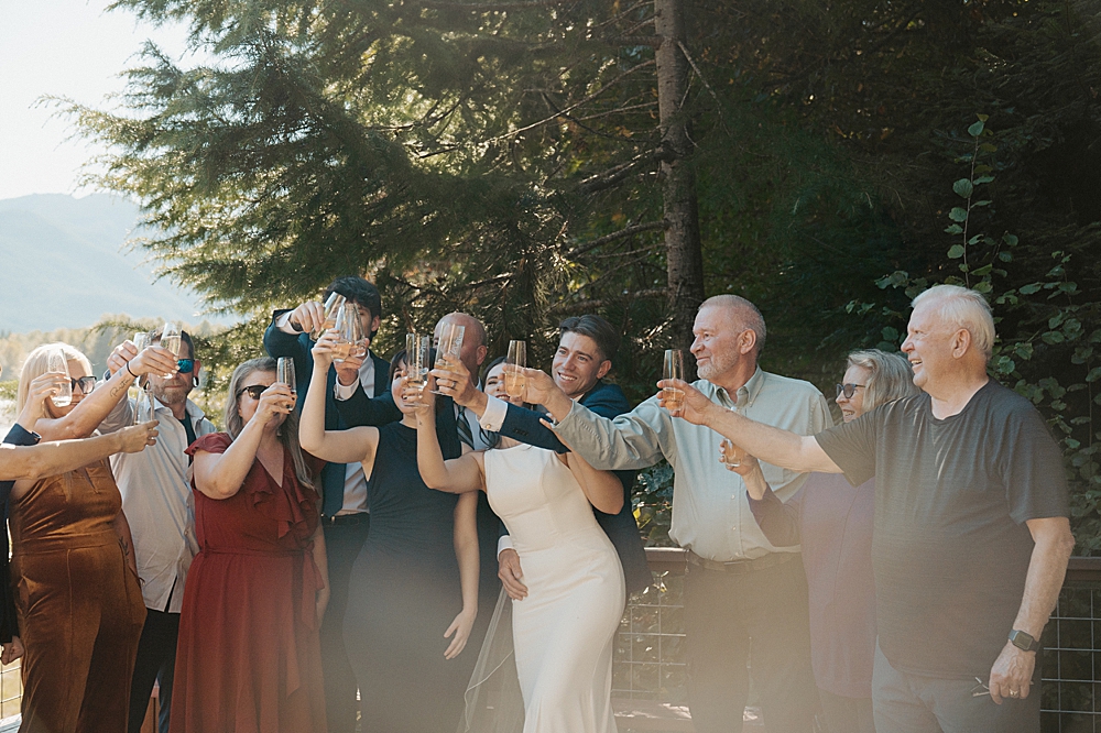 Bride, groom, and family members all lifting their glasses and toasting!