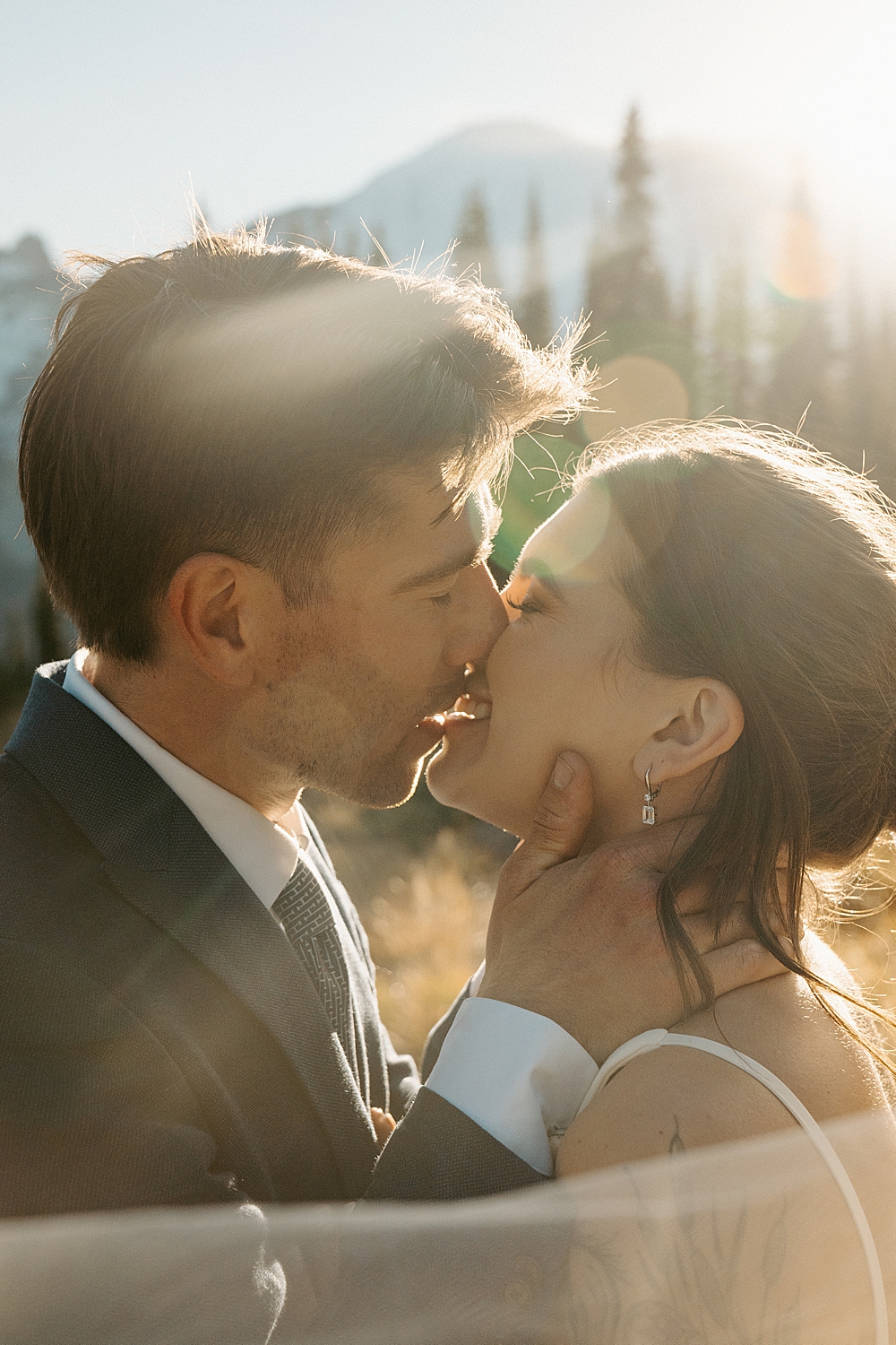 Up close of bride and groom smiling and leaning in for a kiss at their Mount Rainier elopement at sunset.