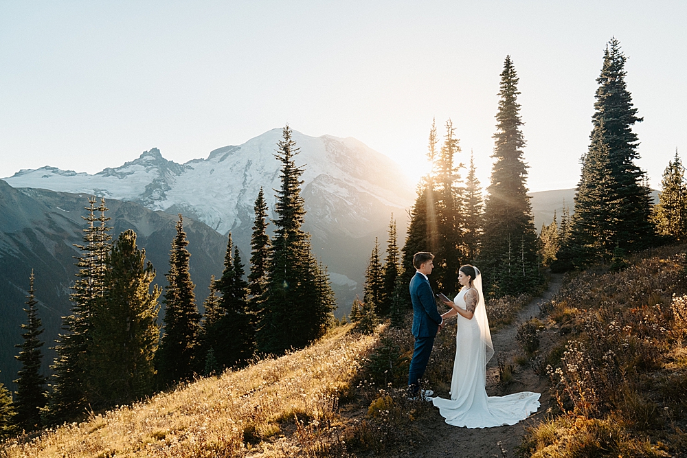 Bride and groom saying vows in Mount Rainier at sunset photographed by Washington elopement photographer, Venture to Elope.