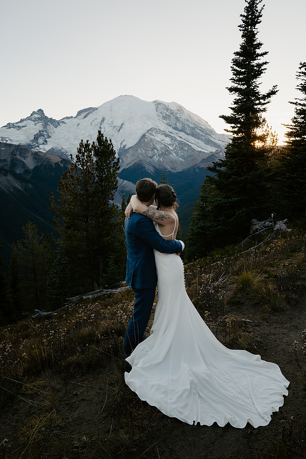Bride and groom holding each other and facing Mount Rainier after the sun set.