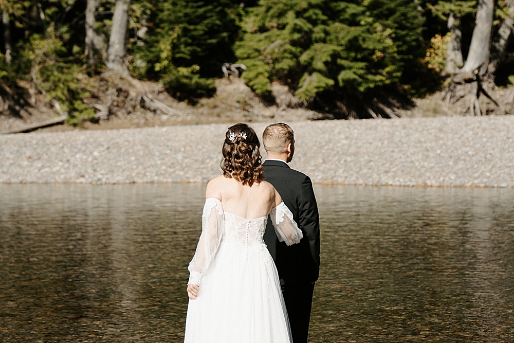Bride and groom sharing a first look at their elopement along Avalanche Creek in Glacier Park captured by Venture to Elope, a Montana photo & video team. 