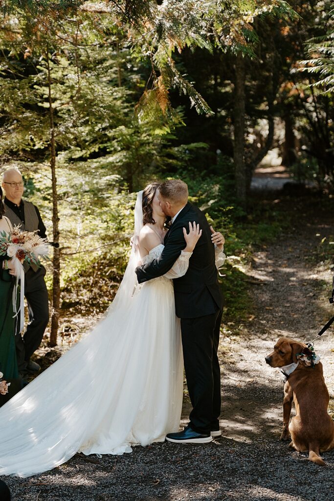 Bride and groom kissing after their small elopement ceremony in Glacier Park at Avalanche Amphitheater, a designated ceremony location within the park.