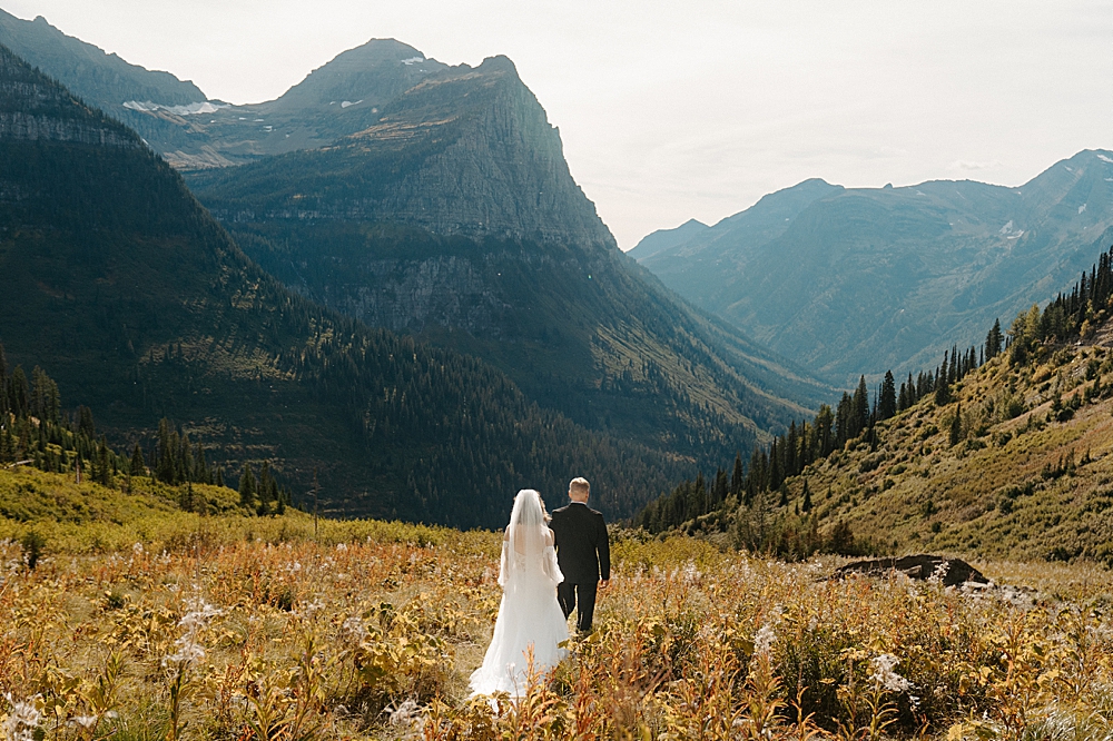 Bride and groom walking amongst the fall foliage at Paradise Meadow in Glacier Park.