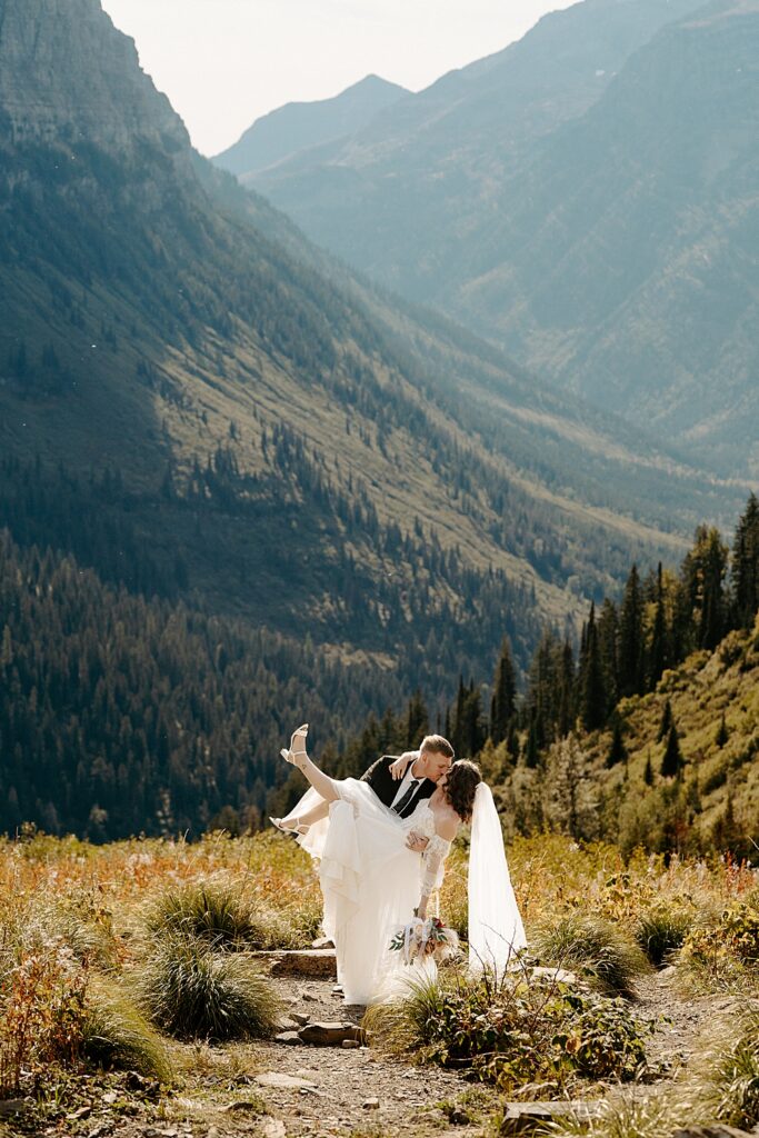 Groom holding bride and kiss dipping her at Big Bend with autumn foliage
