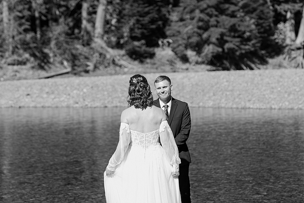 Bride and groom sharing a first look at Avalanche Creek in Glacier Park