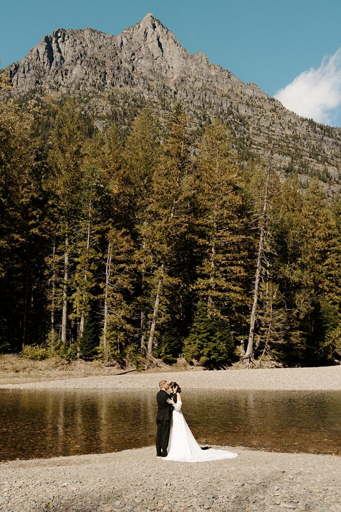 Groom kissing bride's forehead at Avalanche Creek Picnic Area