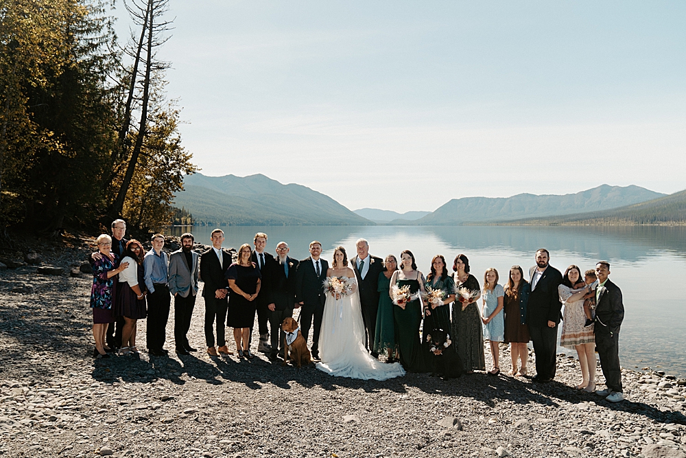 Small wedding party group photo at Lake McDonald Beach in the fall