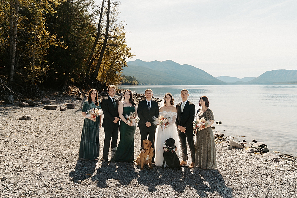 Bride and groom with their bridal party and two dogs at Lake McDonald