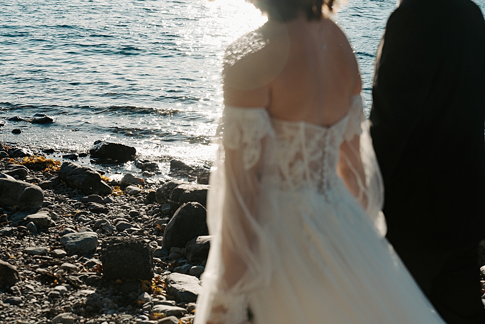 Blurry photo of bride and groom with the focus being the sun on Lake McDonald