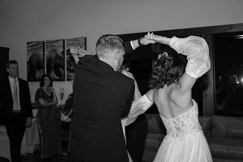 Black and white of bride and groom dancing at their reception