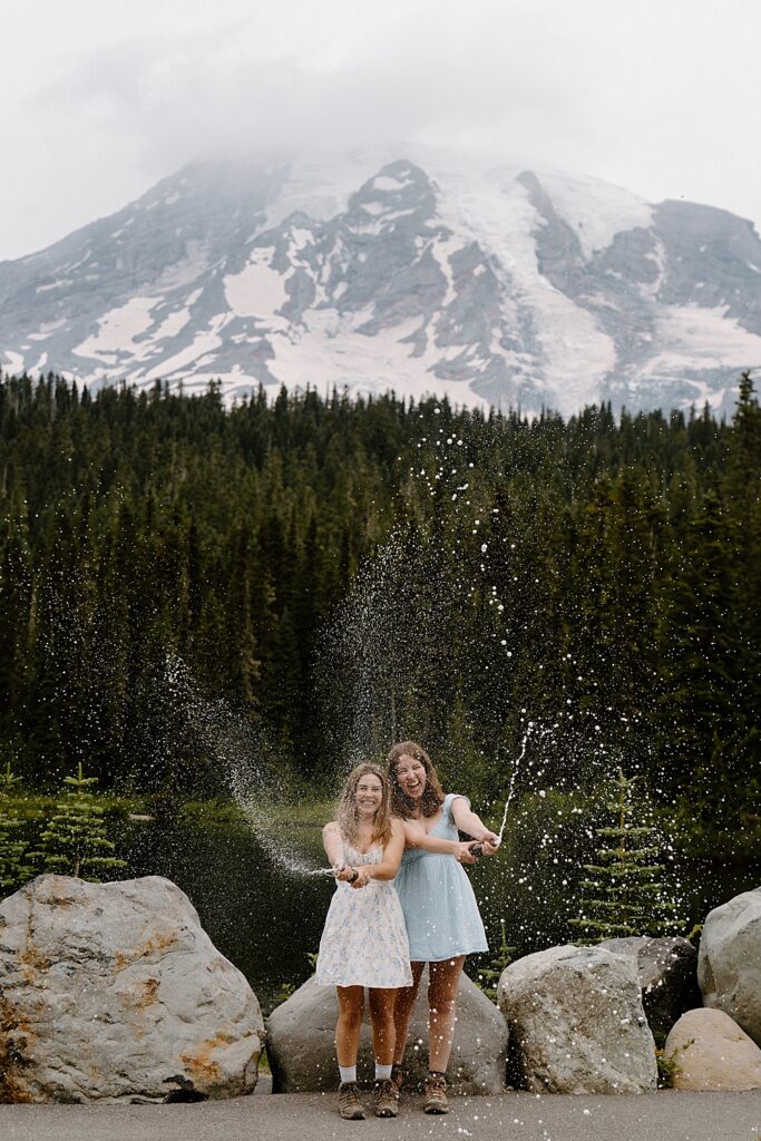Mount Rainier proposal celebration with two girls spraying champagne.