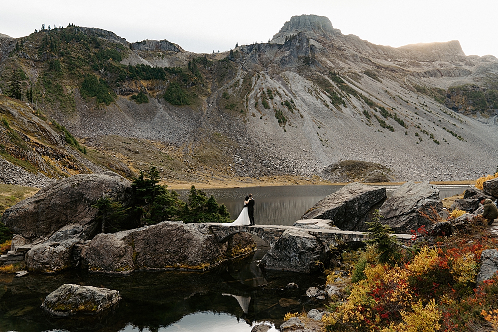 Bride and groom standing on a stone bridge for their Bagley Lakes elopement in Mount Baker-Snoqualmie National Forest. 