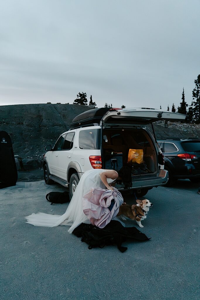 Bride getting ready behind a white SUV before sunrise at Artist Point for her sunrise elopement.