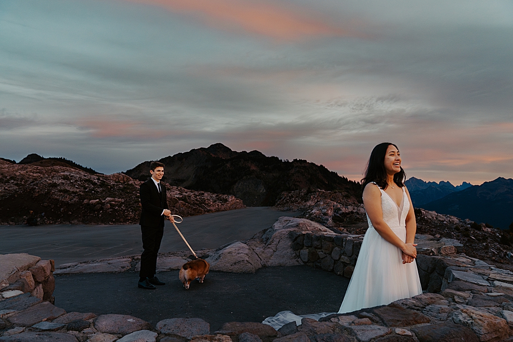 Bride's expression while she's watching the sunrise with her groom and corgi puppy behind her getting ready for their first look.