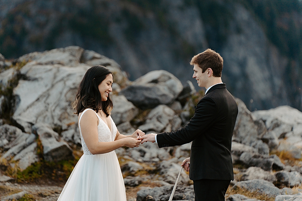 Bride putting a wedding band on groom for their Washington elopement ceremony.