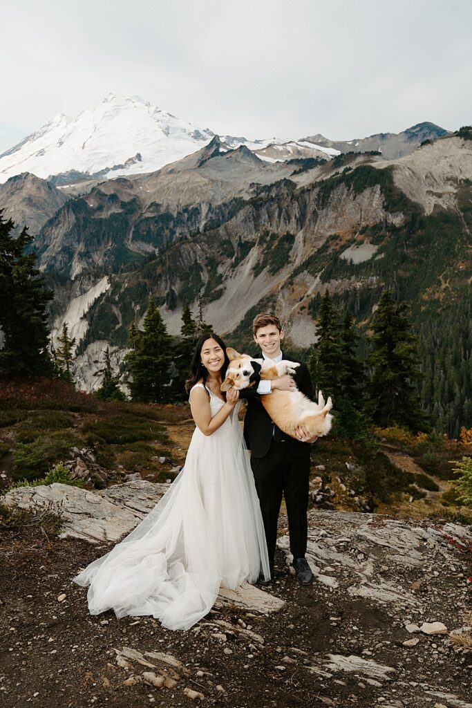 Mount Baker elopement photo of bride standing next to her groom while he's holding their corgi.