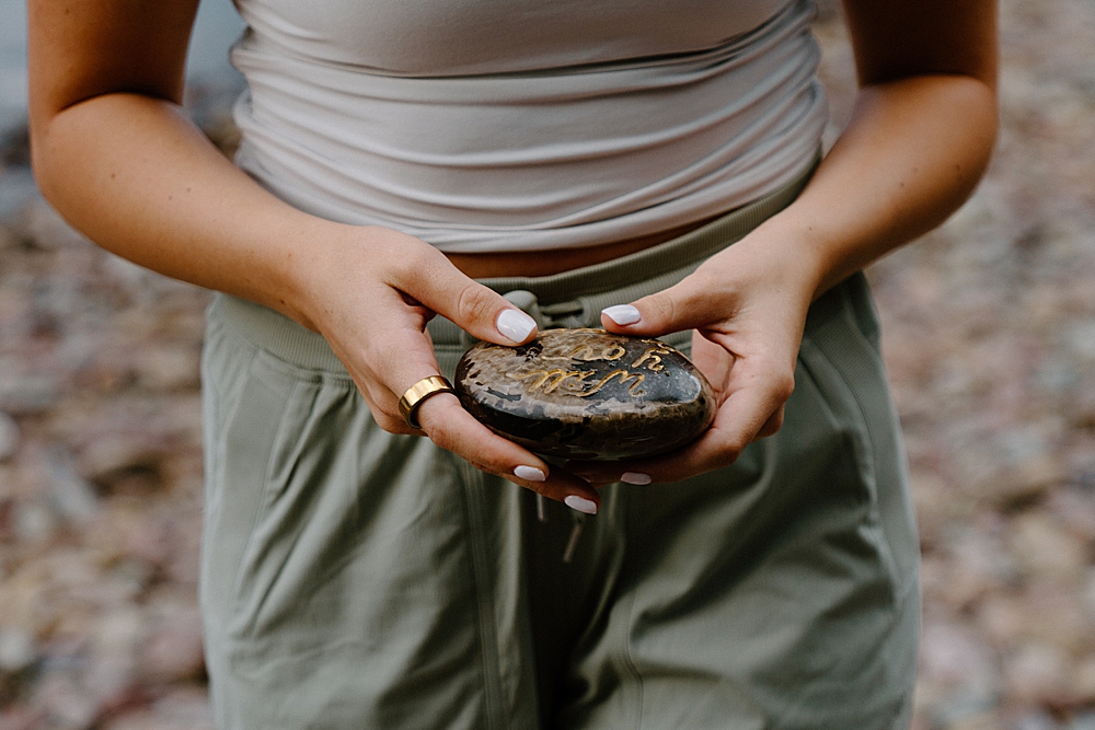 Girl holding a rock that reads "Will you marry me?"