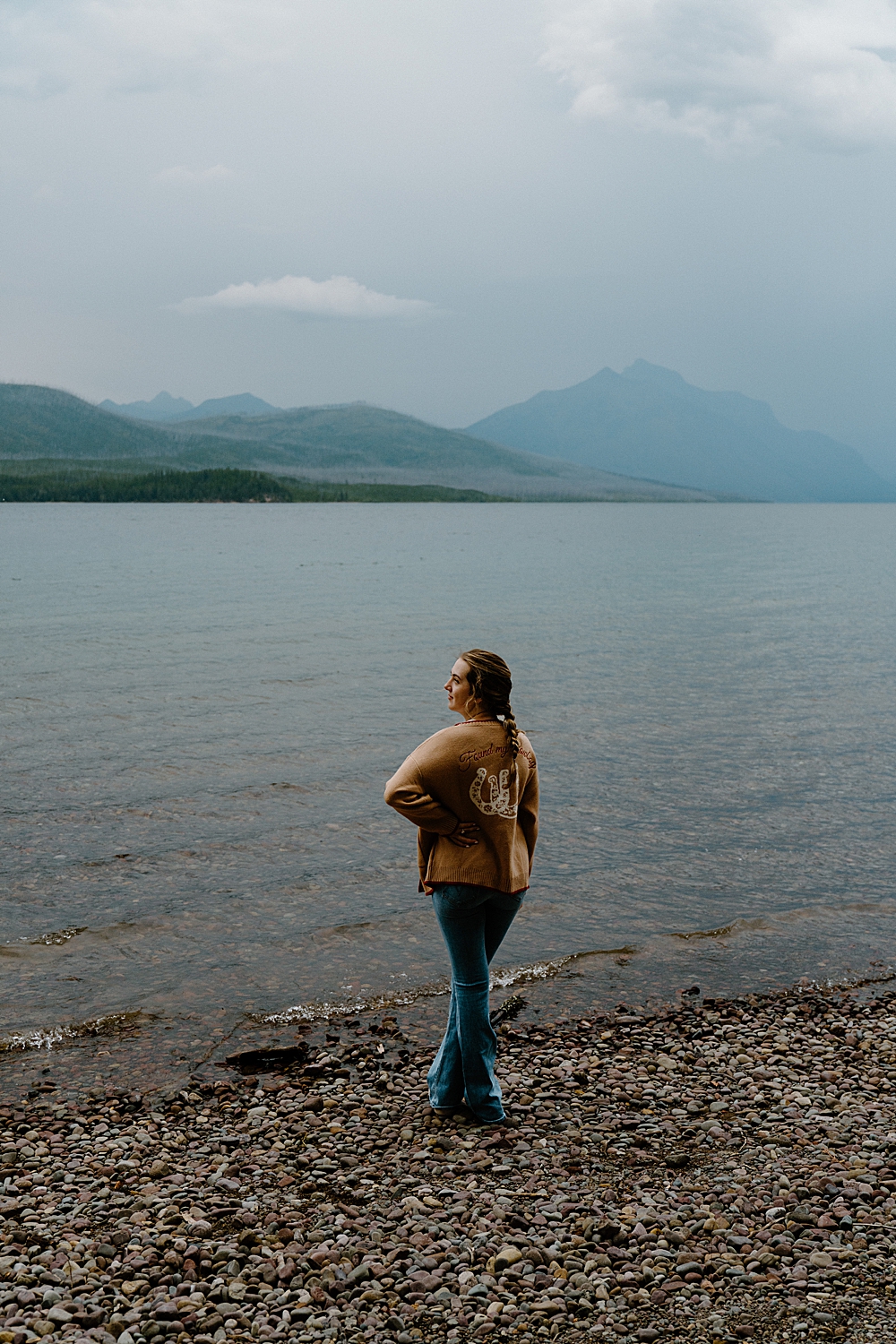 Newly engaged girl facing to the left with Lake McDonald and the mountains in the background