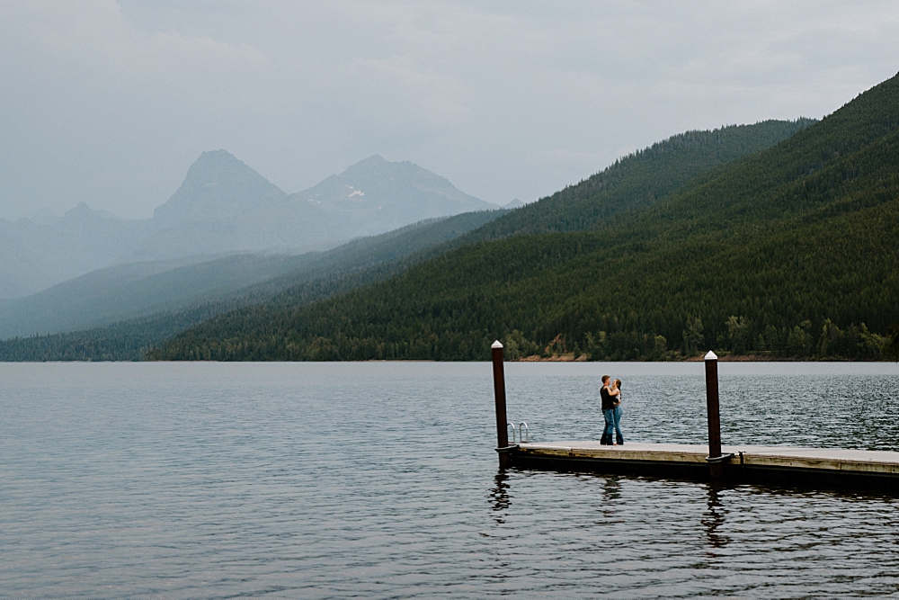 Couple swing dancing on dock at Apgar Beach for their Lake McDonald engagement session in Montana